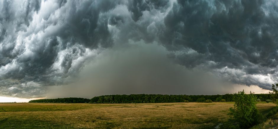 Man bevestigt stormhaken aan tuinhek.